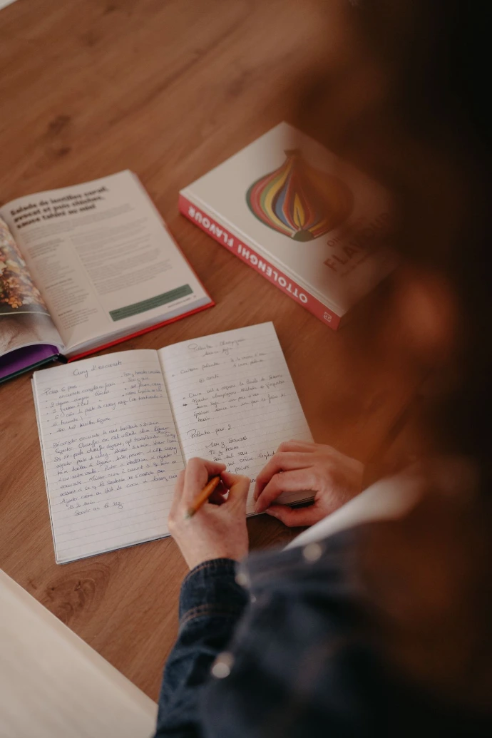 cuisinier qui travaille ses recettes et prépare sa liste de course
